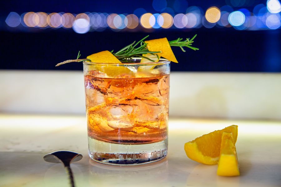 An Old Fashioned cocktail with orange and rosemary